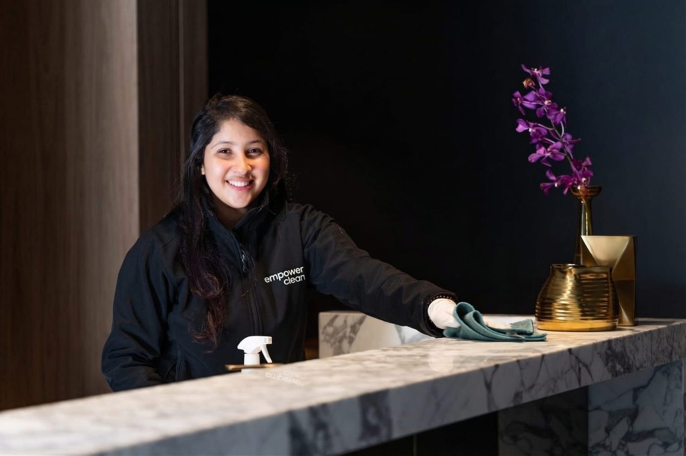 An Empower Clean team member cleaning a reception counter